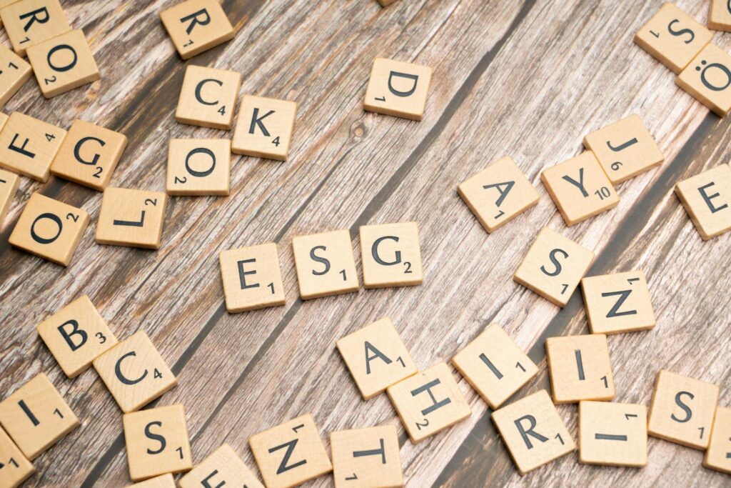 Wooden letter tiles spell ESG on a rustic wooden surface, emphasizing sustainability.